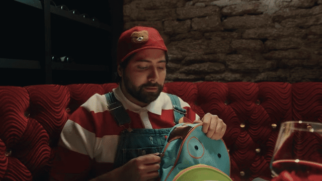 a childish man looking through his backpack at a nice restaurant